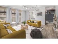 Bright living room with yellow sofas, rug, natural light and balcony access at 620 Peachtree Ne St # 601, Atlanta, GA 30308
