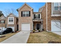 Charming brick townhouse with a one-car garage and well-maintained landscaping at 11130 Benton Woods Dr, Covington, GA 30014