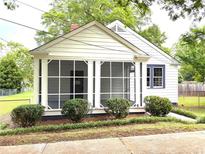 Charming home featuring a screened-in porch and well-maintained landscaping at 5091 Newark Ave, Clarkdale, GA 30111