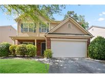 Charming two-story home featuring a brick facade and a two-car garage, surrounded by mature landscaping at 5244 Carrington Park Dr, Powder Springs, GA 30127