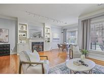 Bright living room features a fireplace, built-in shelves, hardwood floors and neutral decor at 273 12Th Ne St # 421, Atlanta, GA 30309