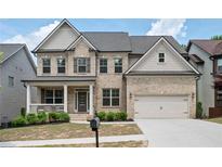 Beautiful two-story brick home featuring a well-manicured lawn, covered porch, and attached two-car garage at 2927 Dolostone Way, Dacula, GA 30019