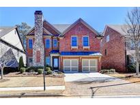 Charming brick home featuring a stone chimney, two-car garage and professionally landscaped front yard at 4892 Kentwood Dr, Marietta, GA 30068