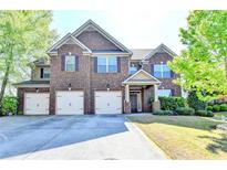 Handsome brick home with an attached three car garage and manicured lawn and garden at 556 Georgia Cir, Loganville, GA 30052