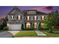Charming two-story home featuring stone accents, manicured lawn, and an attached two-car garage at 2113 Dodson Woods Dr, Fairburn, GA 30213