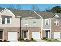 Charming townhome exterior with brick accents, single-car garages, and well-maintained landscaping at 400 Chaleur Way, Locust Grove, GA 30248