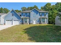 Charming two-story home featuring a two-car garage and beautiful blue siding at 6220 Polar Fox Ct, Riverdale, GA 30296