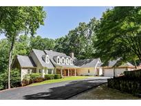 Stunning home showcasing stone and siding exterior, covered front porch, and lush landscaping at 5205 Riverview Nw Rd, Atlanta, GA 30327