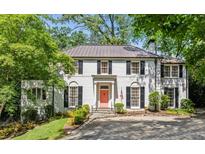 Elegant white brick home features black shutters, a copper roof, and manicured landscaping at 3086 E Pine Valley Nw Rd, Atlanta, GA 30305