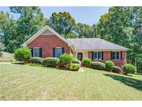 Beautiful brick home with a well-manicured lawn and lush landscaping, enhancing its curb appeal at 2903 Southpark Sw Ter, Conyers, GA 30094