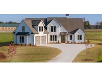Stunning two-story farmhouse with a concrete driveway and well-manicured lawn at 170 Paislee Park (Lot #8 Paislee Park) Dr, Fayetteville, GA 30215