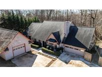 Aerial shot of house with well-maintained lawn, garage, and mature trees at 5479 Dorsett Shoals Rd, Douglasville, GA 30135