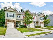 Charming townhomes with well-maintained lawns and attached one car garages on a sunny day at 692 Oakside Pl, Acworth, GA 30102
