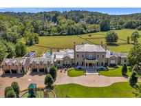 Expansive estate showcasing the home, a pool, manicured lawn, and paddock surrounded by lush greenery at 1040 W Conway Nw Dr, Atlanta, GA 30327