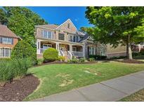 Charming brick home featuring a well-manicured lawn and inviting front porch, perfect for relaxing outdoors at 4731 Moon Chase Dr, Buford, GA 30519
