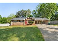Charming brick home with a well-maintained lawn and an inviting red front door at 6459 Paula Ct, Rex, GA 30273