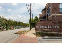 Street view of Mill Town Lofts with brick sign and mural lined street at 791 Wylie Se St # 911, Atlanta, GA 30316