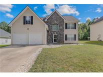Charming two-story home featuring a stone facade, a well-maintained lawn, and a two car attached garage at 240 Creekview Blvd, Covington, GA 30016
