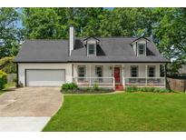 Charming home featuring a red front door, front porch and manicured front lawn at 831 Terrace Trce, Lawrenceville, GA 30044