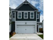 Charming two-story home featuring a two-car garage and a modern, dark-green paneled facade at 1956 Asher Ln # 51, Conyers, GA 30013