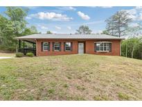 Charming brick home featuring a covered porch and a well-maintained front yard at 3881 Moore Rd, Ellenwood, GA 30294