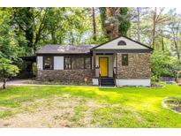 Charming home with stone accents, yellow front door, and well-maintained lawn at 1959 Oana Sw St, Atlanta, GA 30310