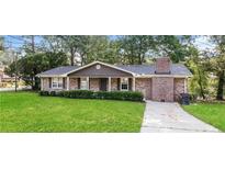 Charming brick home featuring a well-manicured lawn, mature trees, and a classic brick chimney at 2914 Landmark Se Dr, Conyers, GA 30094