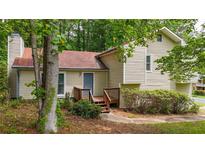 Charming home featuring a front entrance with a small deck and cozy setting among lush greenery and mature trees at 3117 Calumet Nw Cir, Kennesaw, GA 30152