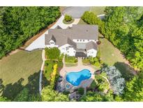 Stunning aerial view of a home featuring a backyard oasis with a large in-ground pool, lush landscaping, and a spacious patio at 110 Hawks Bnd, Canton, GA 30115