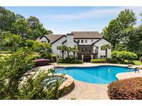Backyard featuring a luxurious pool, stone spa, and lush landscaping, perfect for relaxation and outdoor enjoyment at 110 Hawks Bnd, Canton, GA 30115