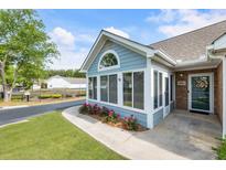 Charming home featuring an enclosed sunroom, flower beds and a well-manicured lawn at 15104 Harvest Ridge Ln, Alpharetta, GA 30022