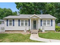 Charming single story home featuring a cozy front porch and blue shutters surrounded by a beautifully landscaped yard at 8136 Connally Dr, Douglasville, GA 30134