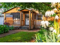 Charming home featuring a welcoming porch, complemented by lush landscaping and a brick pathway leading to the entrance at 625 Kennesaw Ave, Atlanta, GA 30308