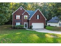 Charming two-story brick home with a well-manicured lawn and attached two car garage at 3910 Knotts Pass Rd, Snellville, GA 30039