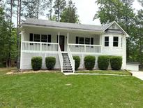 Charming home featuring a covered porch, landscaped front yard, and a welcoming entrance at 1094 Plantation Ct, Villa Rica, GA 30180