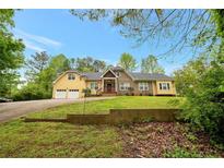 Charming two-story home featuring a two-car garage, brick and vinyl siding, and a lush green lawn at 4050 Old Fairburn Rd, Atlanta, GA 30349