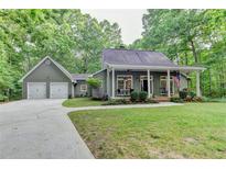 Charming home with a two-car garage, inviting front porch, and a well-maintained lawn at 4490 Highway 138 Sw, Stockbridge, GA 30281