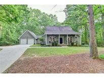 Charming home featuring a covered front porch, attached two car garage and surrounded by mature trees at 4490 Highway 138 Sw, Stockbridge, GA 30281