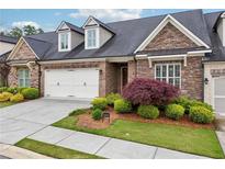 Charming home featuring a well-manicured lawn, stone accents, and a two-car garage at 5695 Overlook Station Dr, Suwanee, GA 30024