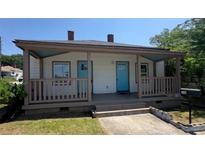 Charming one-story home with a welcoming front porch and light exterior and bright blue doors at 50 Ivy St, Porterdale, GA 30014