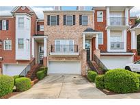 Attractive brick townhome with an attached two-car garage and landscaped front yard at 1215 Comet View Se Trl, Smyrna, GA 30082