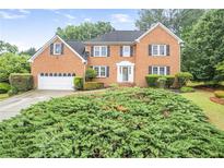 Charming two-story brick home featuring well-manicured landscaping, a two-car garage and inviting front entrance at 435 Trammell Dr, Alpharetta, GA 30009