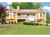 Charming two-story home featuring a welcoming front porch, landscaped yard, and a warm, inviting facade at 55 Cross Pointe Ct, Hiram, GA 30141