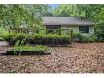 Exterior shot of home with a deck, mature landscaping, and a quaint backyard at 1909 Moores Mill Nw Rd, Atlanta, GA 30318