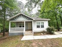 Charming single-story home with a welcoming front porch and beautifully landscaped yard at 2037 Lakewood Trl Se, Atlanta, GA 30315