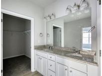 Bright bathroom featuring double vanity, granite countertops, and a walk-in closet at 967 Park Place St, Social Circle, GA 30025