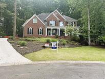 Charming two-story brick home with a manicured lawn and mature landscaping, creating an inviting curb appeal at 1045 River Pt, Suwanee, GA 30024