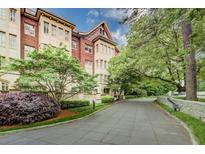 An exterior view of an impressive brick and stone building surrounded by lush landscaping at 1717 N Decatur Ne Rd # 303, Atlanta, GA 30307