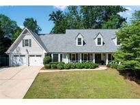 Charming traditional home featuring a two-car garage and inviting front porch with lovely landscaping at 4824 Dunwoody Station Dr, Atlanta, GA 30338