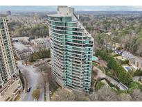 Stunning aerial view of a modern high-rise condo building with a curved facade and lush landscaping at 700 Park Regency Ne Pl # 1203, Atlanta, GA 30326